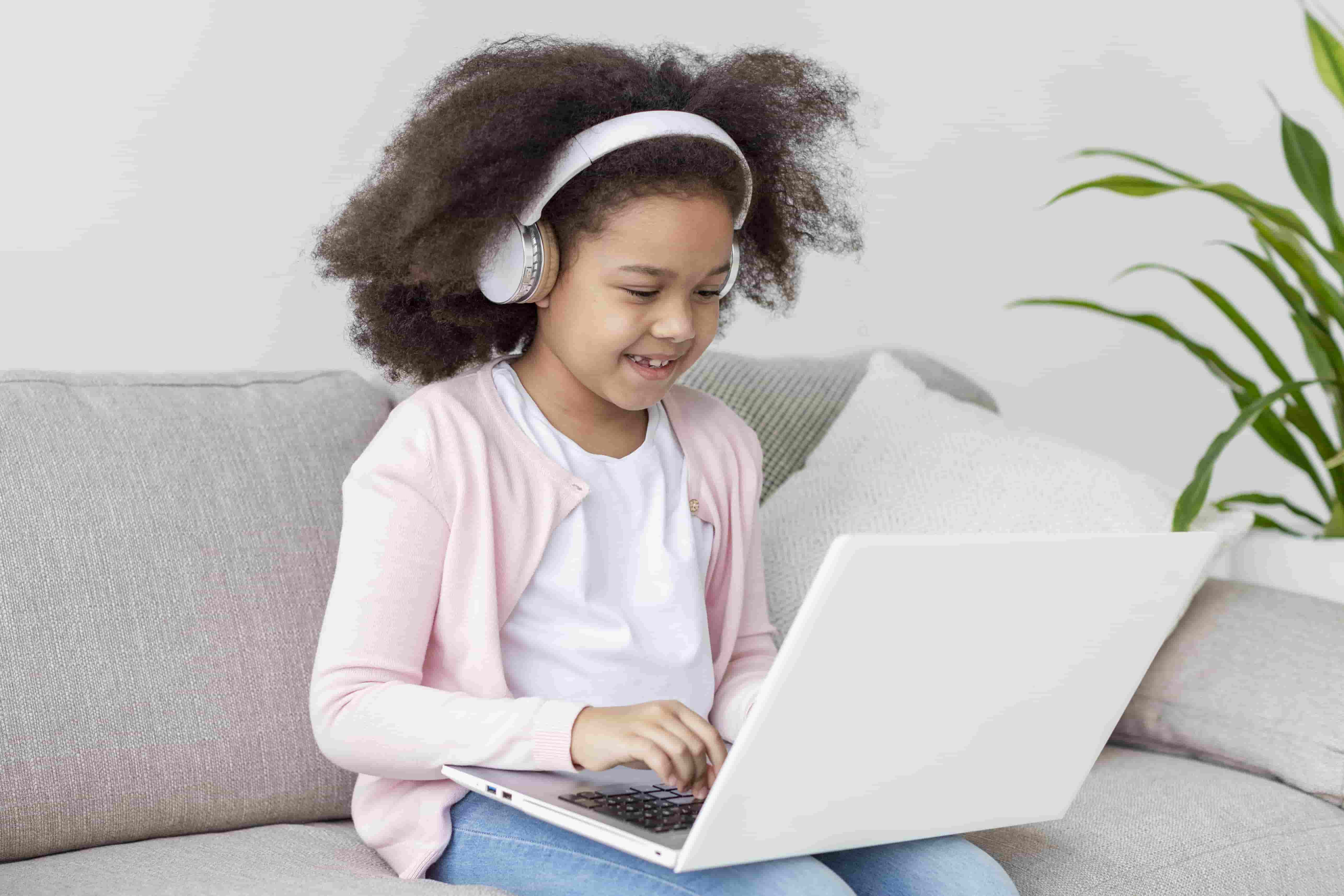 Positive young girl holding laptop
